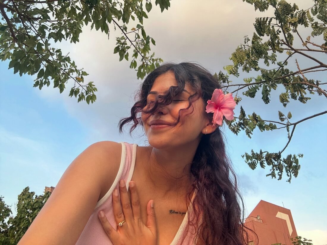 Shreya Jadhav in golden-hour light with a hibiscus flower in her hair