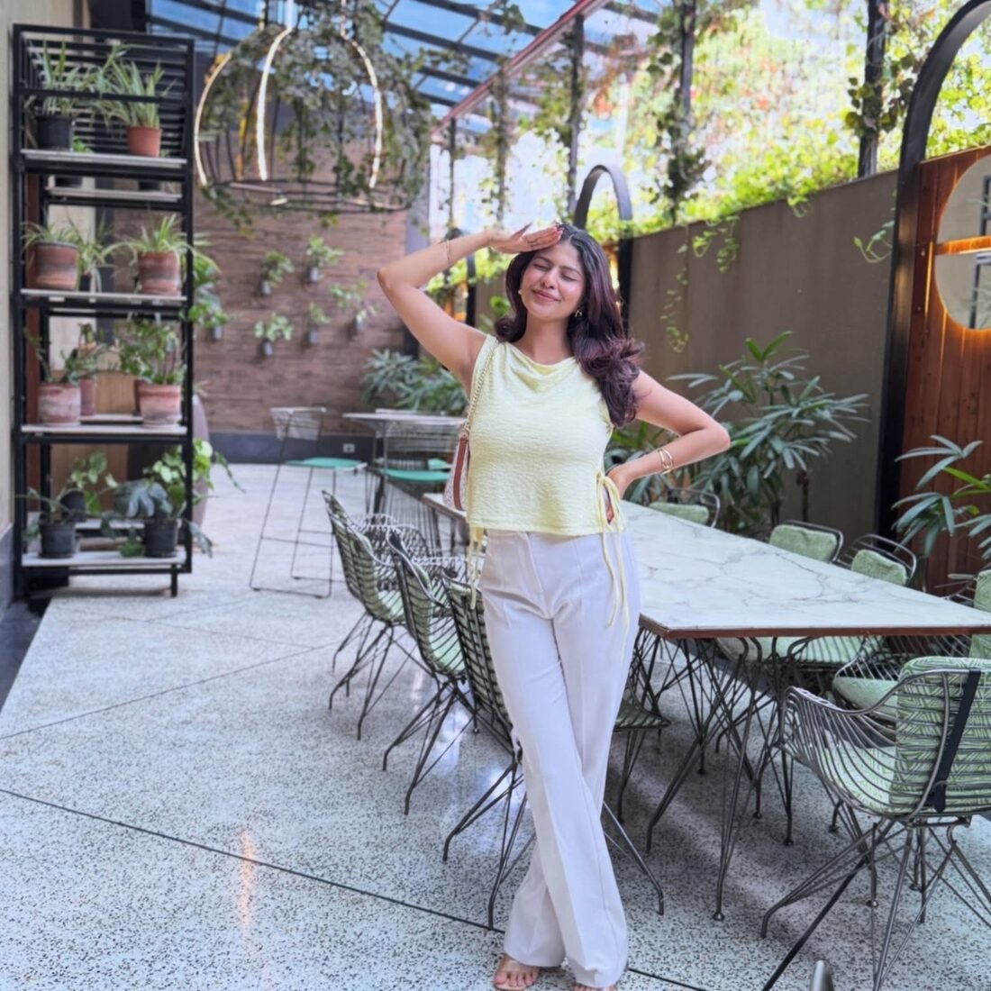 Shreya Jadhav on a plant-filled cafe patio